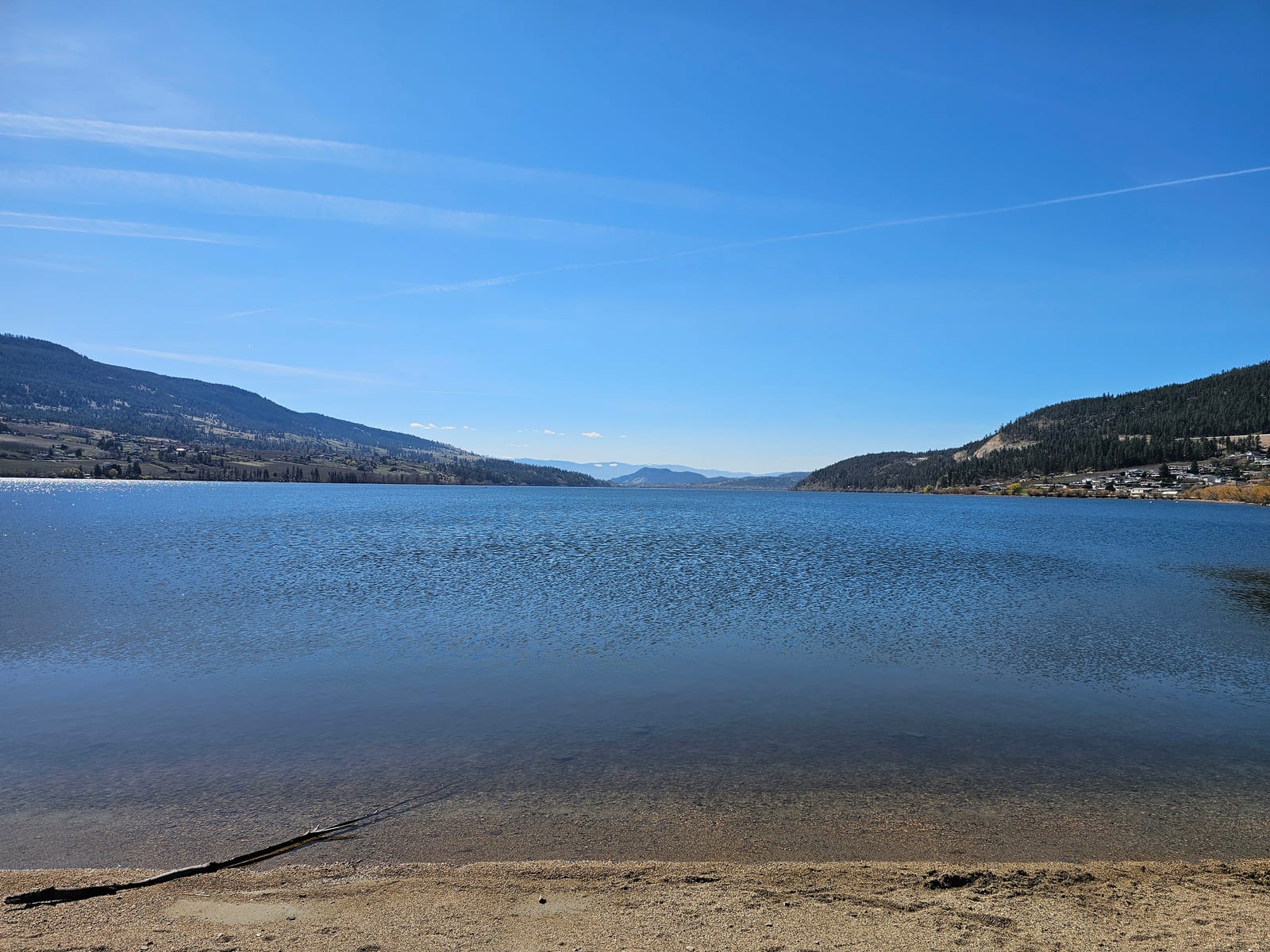 The sandy Wood Lake beach in Oyama, BC, calm, shallow and family friendly